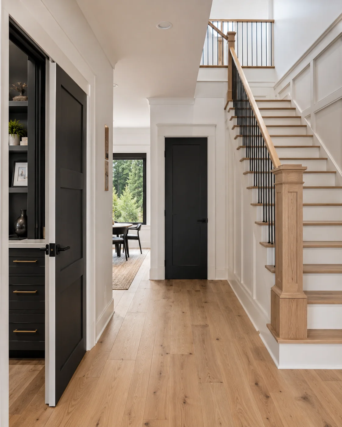Finished home interior with hardwood floors, black interior doors, and a hardwood staircase